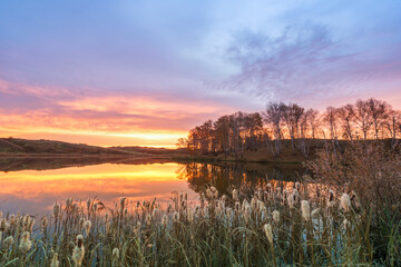 Colorful dawn in village of Osinovka on the lake shore in the Kurgan region of Russia