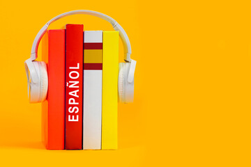 Learning Spanish, Headphones and Textbooks. Listening to Spanish Literature Books, Audiobook. Flag...