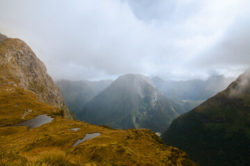 Hazy mountains covered by fog .view from Mackinnon Pass, Milford Track, New Zealand