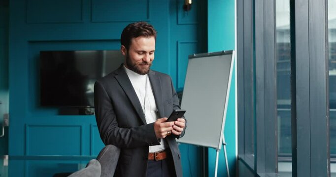 Happy, businessman and window with phone for communication, business proposal or chat at office. Man, financial advisor or accountant typing with mobile smartphone for finance ap or online advice