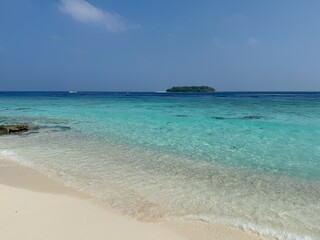 Beach and ocean water with island from Maldives