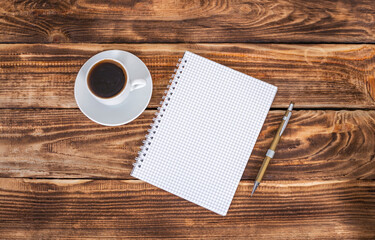 cup coffee ,notebook and pen on wooden background