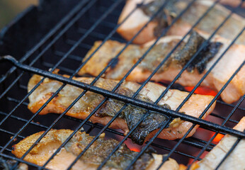 Grilled trout fish sizzling on the barbecue during a summer gathering in a serene outdoor setting