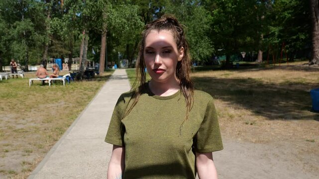 Portrait young woman in green t-shirt in sunglasses walking. Sporty woman. slow motion portrait