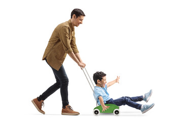 Father pushing son in a small wooden toy cart © Ljupco Smokovski