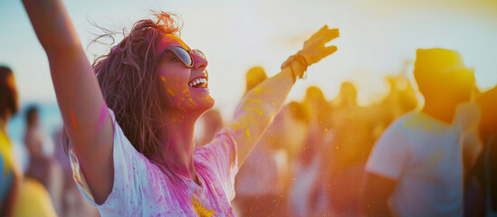 Obraz premium Young woman joyfully celebrating Holi with vibrant colors in the air. A perfect representation of happiness, freedom, and festive spirit, ideal for cultural and lifestyle themes
