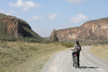 Fototapeta premium Une touriste fait un safari en vélo - Hell's gate au Kenya