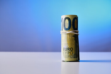 A 100 euro bill is wrapped in a string. Concept of wealth and luxury, as the bill is worth a significant amount of money. The string around the bill adds a sense of security and protection