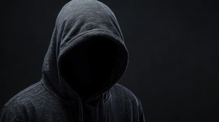 Silhouette of a hooded man on a dark background. The face is hidden. Computer hacker spy. Hacker attack, virus infected software, dark web, scam project fraudulent cheater concept.