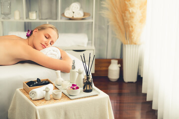 Caucasian woman customer enjoying relaxing anti-stress spa massage and pampering with beauty skin recreation leisure in day light ambient salon spa at luxury resort or hotel. Quiescent
