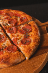 Detail view of a piece of pepperoni pizza on a cardboard box ready for delivery