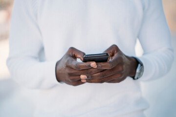 Close-up of black man using smartphone, mobile technology and communication