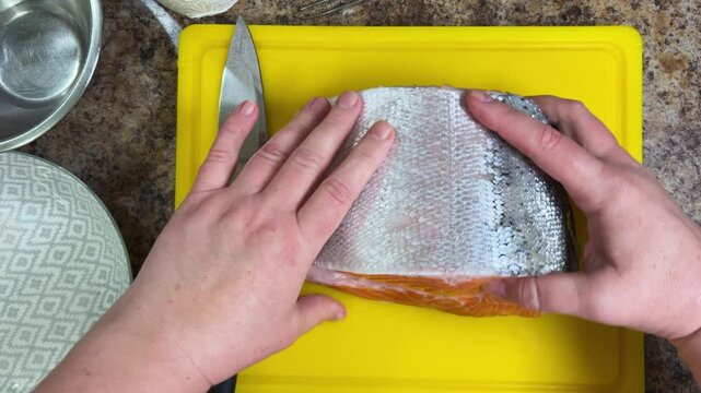 cutting salmon fish with a knife for further
