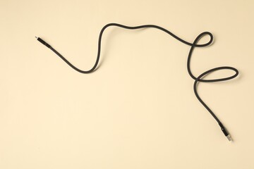 One USB charge cable on beige background, top view. Space for text