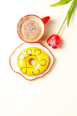 A yellow donut, a red coffee cup, and a tulip arranged in the shape of the number eight. A festive composition for International Women's Day.
