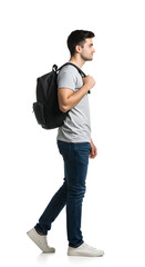 Fototapeta premium Side view of a young man walking with a backpack, wearing casual clothes, showcasing confidence as a commuter, isolated on a white background for a sleek, modern look, isolate white background