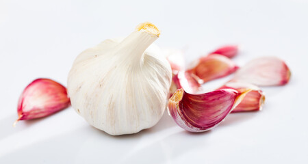 Garlic cloves over white background. Fresh unpeeled garlic.