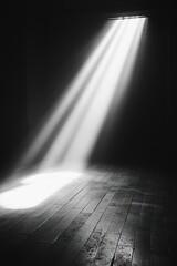 A black and white photo capturing a single light beam shining on a floor, creating a dramatic and moody atmosphere.