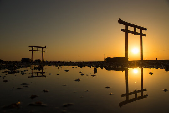 Wide shot of water torii and its reflection at a dawn