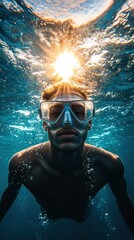 Fototapeta premium Man swimming underwater with a snorkel, illuminated by sunlight