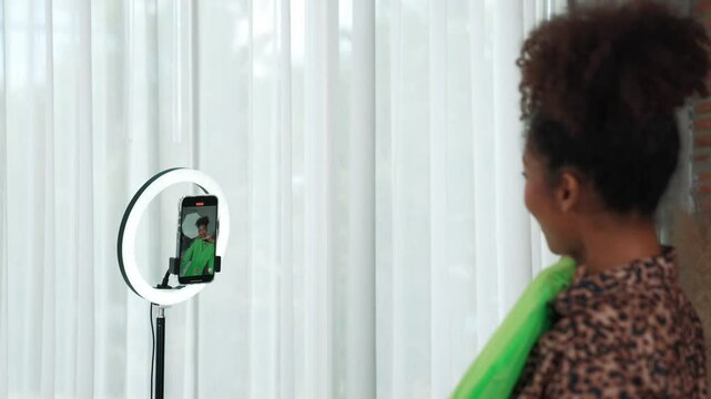 Rear view behide woman influencer shoot live stream vlog video review clothe crucial social media or blog. Girl with apparel studio lighting for marketing recording session broadcasting online