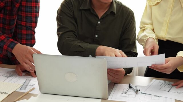 Smart architect and safety engineer discussion about building plan on table with architectural document, measurement tools and wooden block scatter around at modern office. Closeup. Delineation.