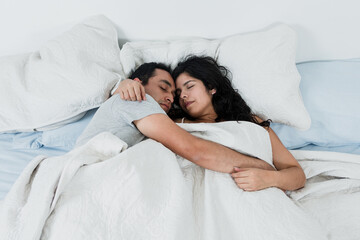 young latin couple sleeping at night on bed at home in Mexico Latin America, hispanic people...