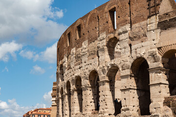 Fototapeta premium detail of the colosseum on a sunny day with clouds