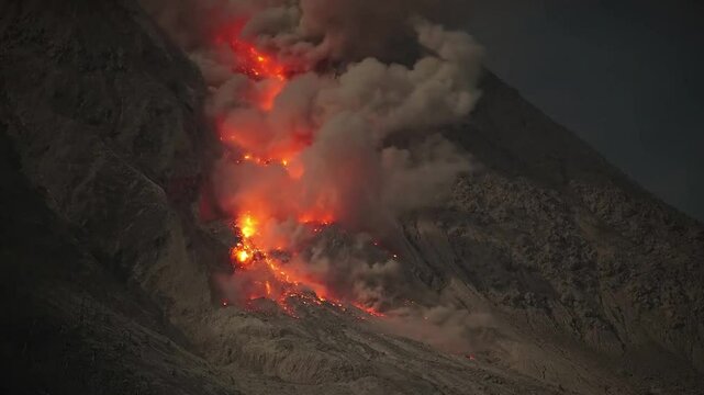 Glowing rockfall of hot lava cascading down the flank of Mount Sinabung volcano, Indonesia.