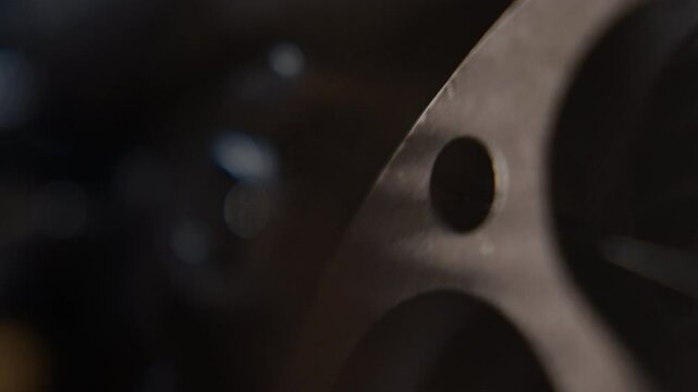 Close ups of a vintage 8MM projector spools moving and playing film 