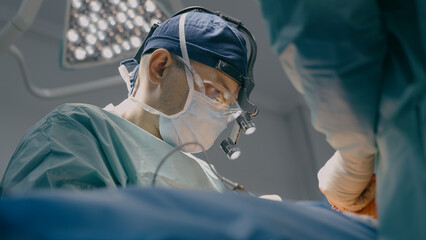 Close up surgeon man in protective mask physician doctor medic team operate patient laparoscopy...