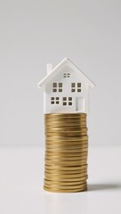 A miniature house on piles of coins signifies financial stability and prosperity through home ownership in real estate