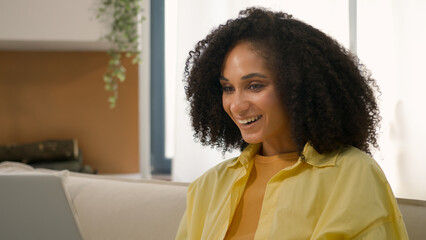 Shocked amazed African American ethnic happy girl 20s woman surprised good news amazement work at...