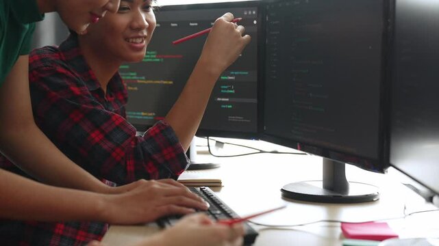 Slow motion back end software developer engineer for computer programming working together on debugging writing computing code, solving complex algorithms display on monitor in office. Burgeoning