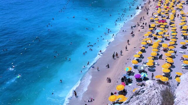 Antalya, August 2024: People sunbathe and swim on Kaputas beach in Turkey on the Mediterranean coast. A beach with clear turquoise waters of the sea, between the towns of Kash and Kalkan. 4K