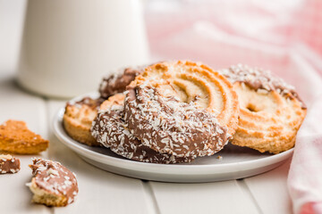 Sweet chocolate cookies on plate on white table.