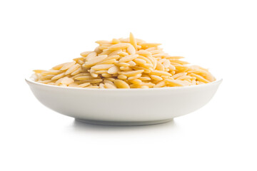 Orzo, kritharaki, risoni pasta. Uncooked dry pasta in bowl isolated on white background.