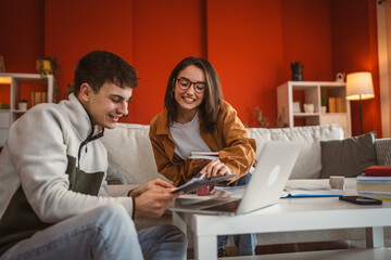 two students man and woman use laptop for prepare exam at home