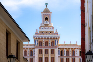 The Bacardi Building in Havana, Cuba, showcases stunning Art Deco architecture with intricate details, colorful tiles, and a majestic tower against a clear blue sky.  