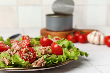 Plate with delicious tuna salad on white tiled table