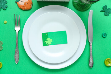 Beautiful table setting for St. Patrick's Day celebration on green background