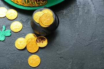 Leprechaun hat with pot of coins and paper clover on black grunge background. St. Patrick's Day...