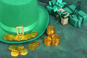 Leprechaun hat with golden coins and gifts on green grunge background. St. Patrick's Day celebration