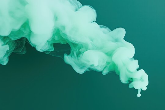 Close up of emerald green smoke creating abstract patterns against a teal backdrop, ideal for backgrounds and artistic projects