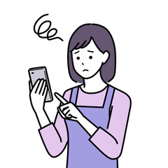 困った顔でスマホを操作するエプロンを着た主婦