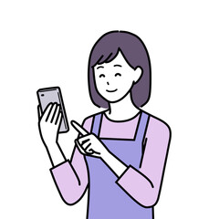 笑顔でスマホを操作するエプロンを着た主婦