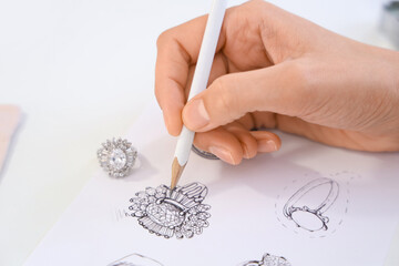 Female jewelry designer drawing sketch for stylish accessory at workplace
