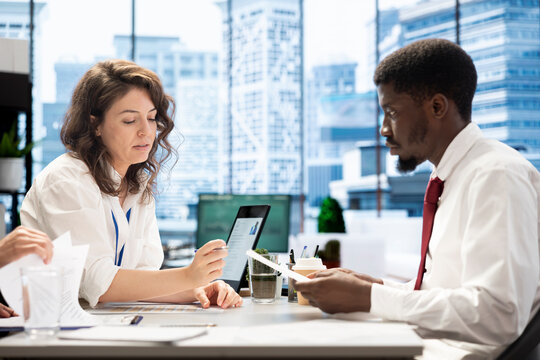 Teamworking employers conducting interview with jobseeker to determine suitability for company position. Human resources colleagues reviewing resume to determine if necessary qualifications are met