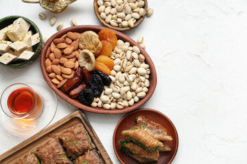 Composition with traditional Eastern sweets and tea for Ramadan on light background