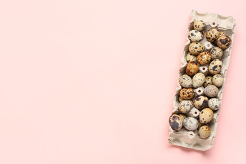 Obraz premium Cardboard holder with fresh quail eggs on pink background